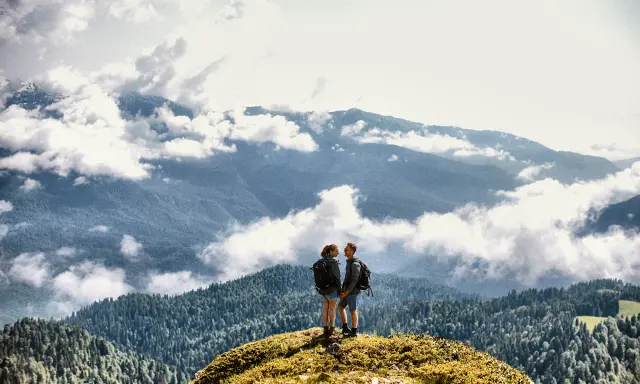 Couple on a mountain peak above the clouds